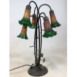 A 6 light table lamp in the style of Dale Tiffany decorated with dragonflies and lilies. A solid