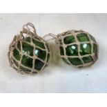 A pair of vintage green glass fishing floats. H:13cm