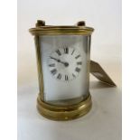 A circular brass mantle clock with bevelled glass. Made in France. Damage to glass front and crackle