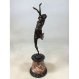 After Bruno Zach ( 1891-1945) Dancing woman. a bronze figure of a dancer with raised arms on a red