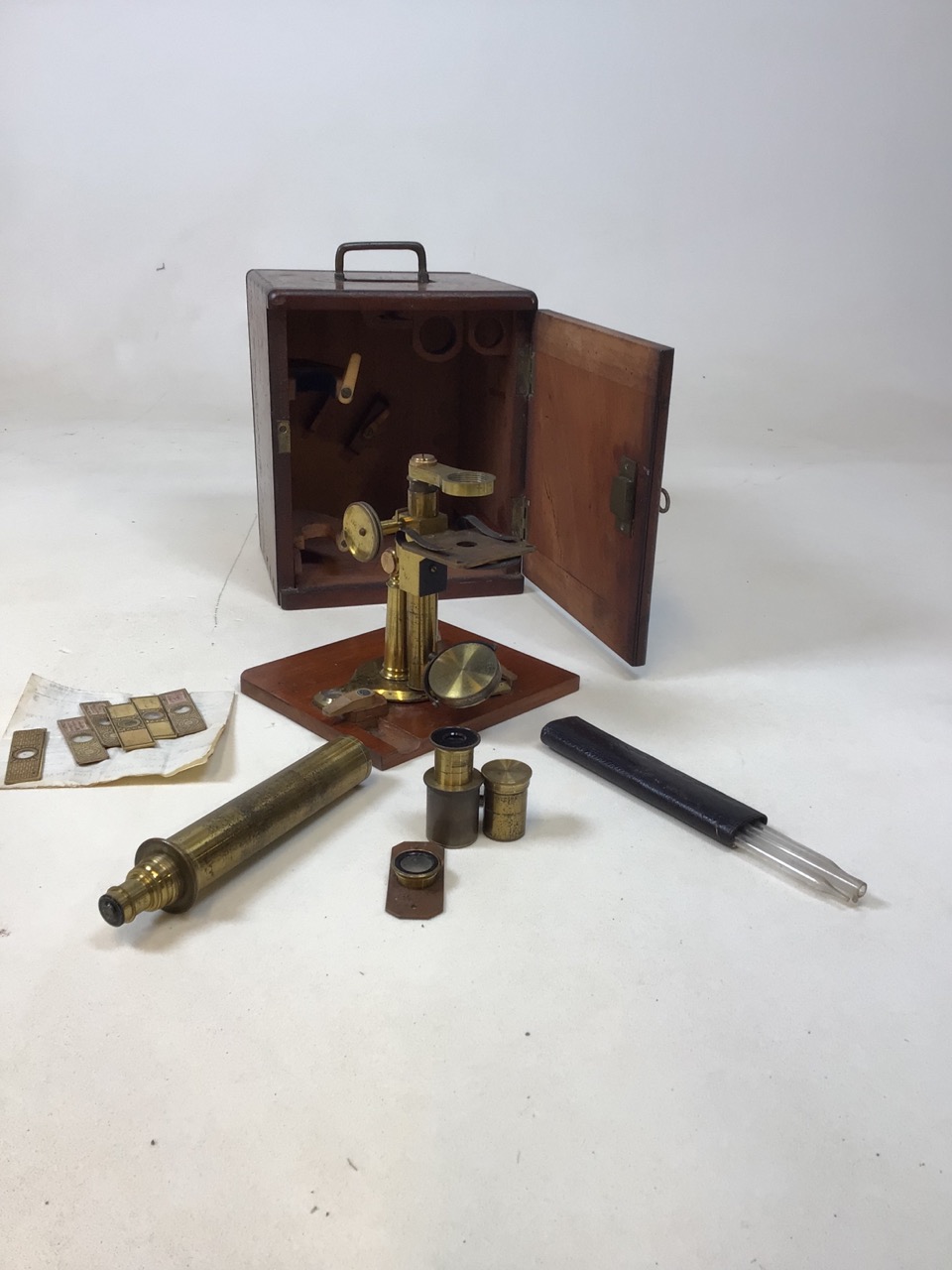 A brass microscope by Negretti & Zambra in original mahogany case with lenses and slides W:18cm x