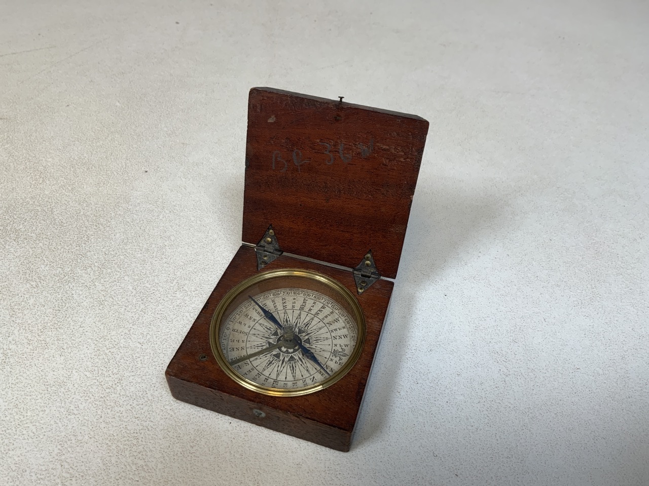 A nineteenth century mahogany cased pocket compass with paper dial and blue compass needle. No front