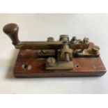 A Morse code machine on wooden plinth. W:15cm x D:7.5cm x