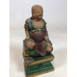 A part glazed ceramic statue of a buddah W:13cm x D:19cm x H:28cm