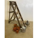 Galvanised watering cans, terracotta pots and vintage step ladders.