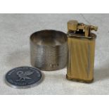 A unique Dunhill lighter 50640 also with a silver napkin ring and King Coillegeb tail ton