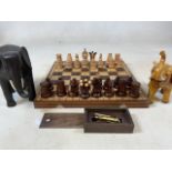 A wooden chess set (complete) also with two wood effect elephants etc.