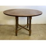 An oval oak table with turned legs and x stretcher. W:100cm x D:80cm x H:70cm