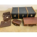 A wood bound travelling trunk also with vintage leather cases a and satchels.