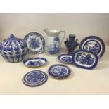 A quantity of blue and white ceramics including Willow pattern plates, a large jug and a large