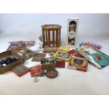 A mixed lot of items including childrens books, dolls, dominoes, draughts, a small glass display