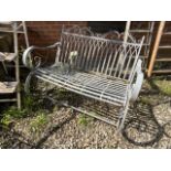 A decorative Victorian style metal garden bench with scroll arms.