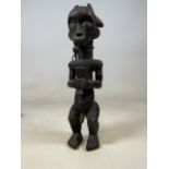 Tribal art. A Fang tribe ancestral carved wooden male figure with boars tusk and antelope point with