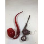 A Nailsea ruby glass pipe together with a wooden and metal trimmed pipe. Height of glass pipe 47cm
