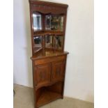 A Two piece corner cupboard with bevelled mirrors turned supports and carved doors. W:42cm x D: