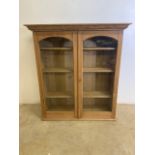 An antique pine glazed bookcase with three adjustable shelves and working key. W:104cm x D:37cm x