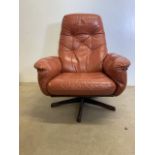 A mid century Gote Mobel Nassjo, Swedish leather swivel arm chair, with rosewood base. With label