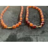 Two amber reconstituted necklaces.