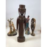 A carved Eastern figure with another wooden figure, a ceramic Naisianoi figure and a leopard