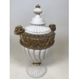 A decorative footed urn in classical style with gilded rams head handles Medallion embedded in