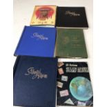 Stamp albums partially completed with world stamps - including Fujairah stamps