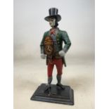 A Continental cast iron figural clock man with top hat. With key on square base. H:40cm