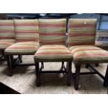 A set of twelve low mahogany standard chairs, each back and seat with brass studded upholstery, in
