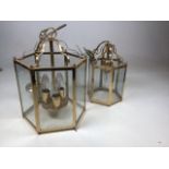A large hexagonal brass hall lantern with glass panels in the traditional style, and a smaller