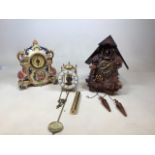 Three clocks to include a modern resin cuckoo clock, a continental clock in ceramic case, and one