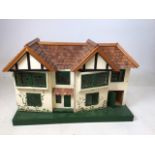 A Triang dolls house with integral garage, shingled roof and some furniture W:67cm x D:47cm x H: