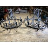 A pair of wrought iron 'wheel' chandeliers, with 8 lights on simple circular frame, adorned with