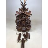 A Black Forrest style carousel cuckoo clock ornately carved with squirrels, stags and leaves. With