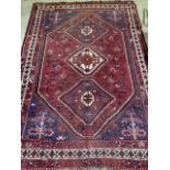 A Shiraz rug with three central medallions on red ground. W:300cm x H:204cm