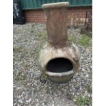 A clay chimenea on metal stand H:92cm