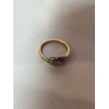A diamond trilogy twist ring, gold metal - un hallmarked. Size 6.5. Total weight 3 gm