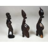 A pair of African carved ebony/hardwood tribal figures of women with drums, and one other. H:25cm