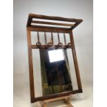 A wooden hall mirror with turned spindles, coat pegs and shelf W:58cm x H:81cm x D: 24cm