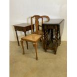 An oak barley twist table with two wicker seated chairs and a small table with drawer. Table un open