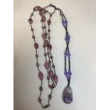 Two beaded necklaces including a rough hewn pendant with purple bead decoration.