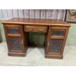A Victorian pine pedestal desk with central drawer flanked by cupboards with shelves. With brass