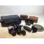 A Canon EOS 650 camera with a 50mm lens, a zoom 70-210mm in bag, a vintage Kodak Brownie In a