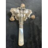 A silver hallmarked babyâ€™s rattle with mother of pearl handle.