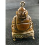 9ct gold and tigers eye Buddah. Buddah seated on gold throne. Total weight 7gm W:2.1cm x H:2.9cm