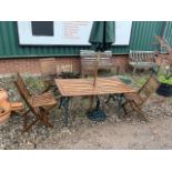 A Teak garden table with metal base with umbrella and stand and four folding chairs. W:138cm x D: