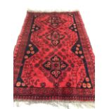 A small Persian red and blue rug. W:112cm x H:80cm