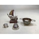 A hallmarked silver tea strainer and bowl, total weight 85gm with white metal items, a sailing