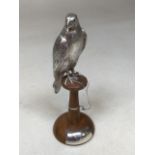A silver falcon on wooden stand - hallmarked for London 1975. Total weight 263 gm H:18cm