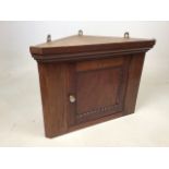 A small mahogany corner cupboard with glass handle W:52cm x D:29cm x H:38cm