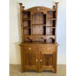 A two piece country pine kitchen dresser. Decorative top with pigeon hole shelves, base with two