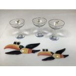 A pair of ceramic flying toucans together with three Babycham glasses